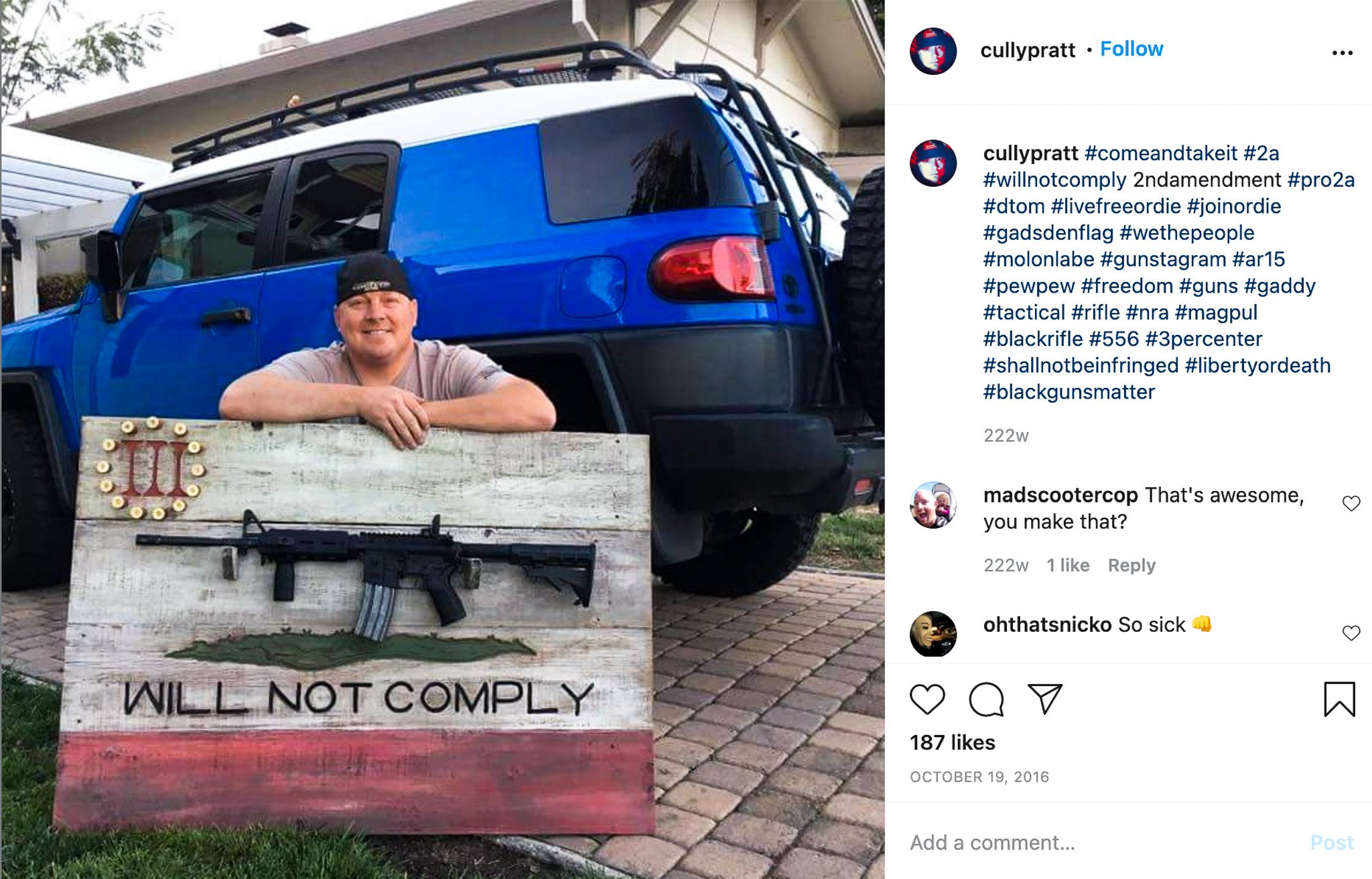 Solano County Sheriff's Sgt. Cully Pratt poses in a driveway with a Three Percenter-themed rifle display rack he made for his colleague, Sgt. Roy Stockton. A black AR-15 semiautomatic rifle is mounted on the rack.