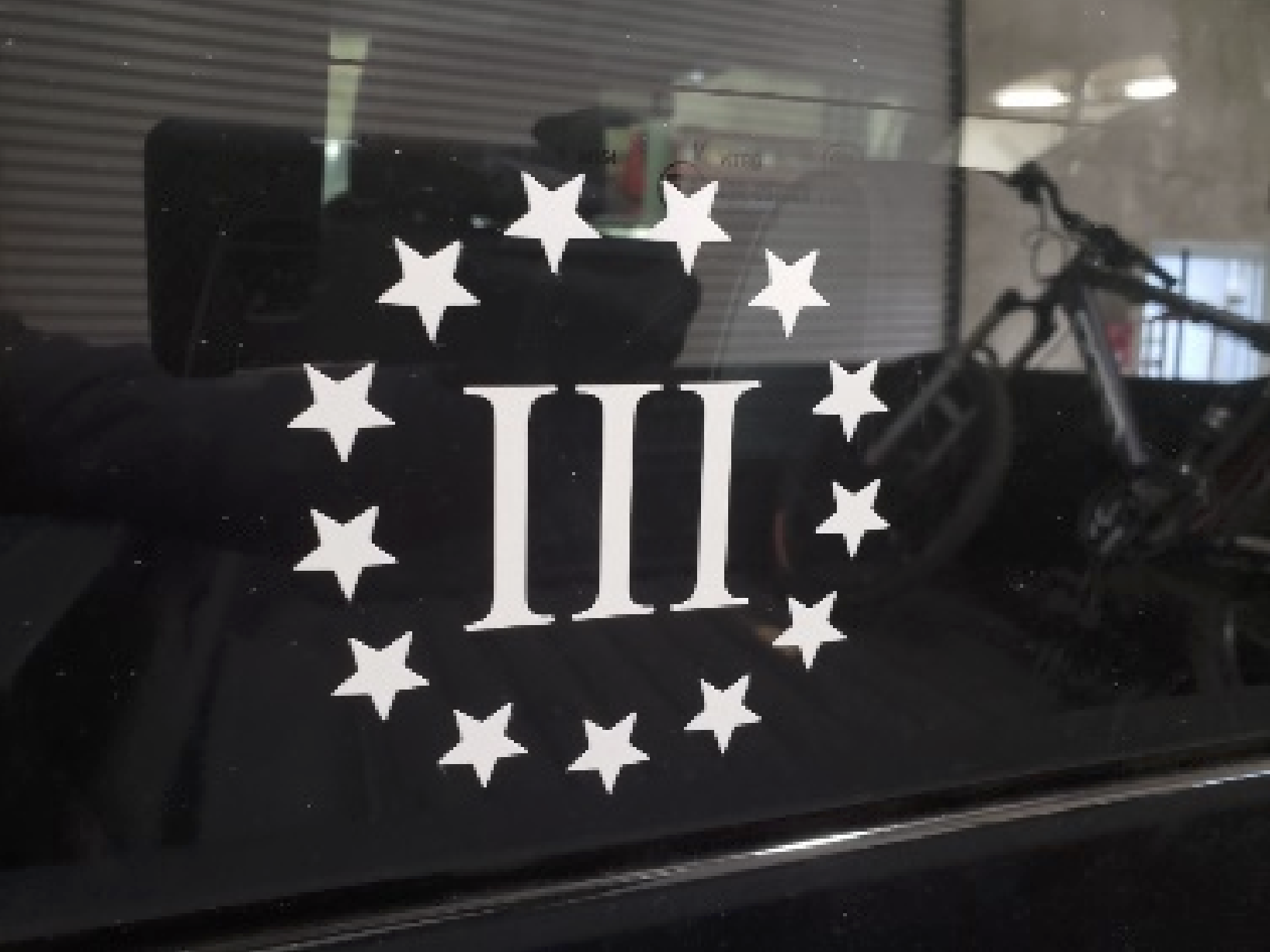 A photograph of the Three Percenters militia logo, comprised of the Roman numeral III surrounded by 13 stars, from the federal criminal complaint against Napa resident Ian Rogers.