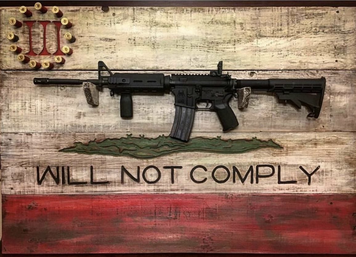 An AR-15 rifle on a display rack bearing the words, "WILL NOT COMPLY" and the logo of the Three Percenters, a far-right militia linked to violence across the country.