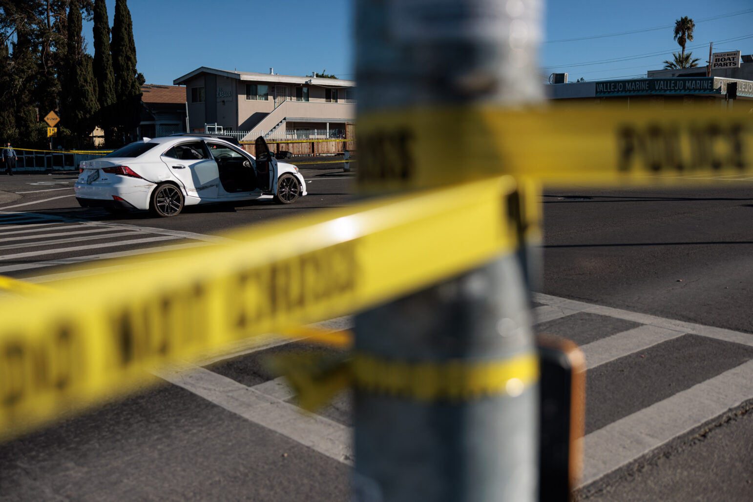 A white Lexus behind crime scene tape