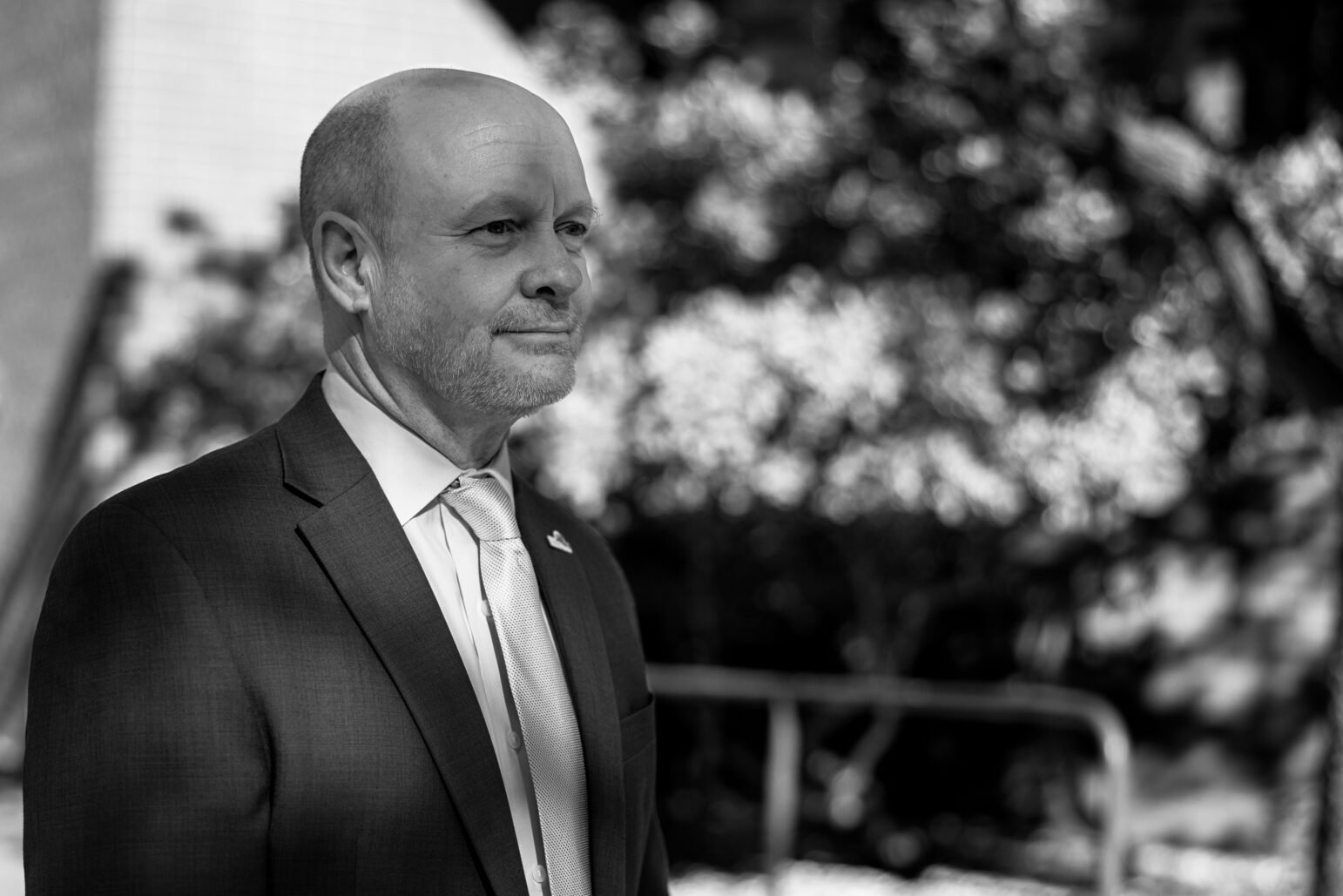 A black-and-white portrait of Andrew Murray in an outdoor setting, dressed in a formal suit and tie, looking off into the distance with a composed expression.