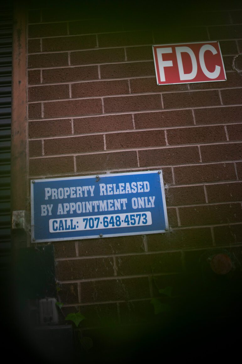 A blue sign on a brick wall that reads, "Property released by appointment only" and, below that, "call: 707-648-4573."