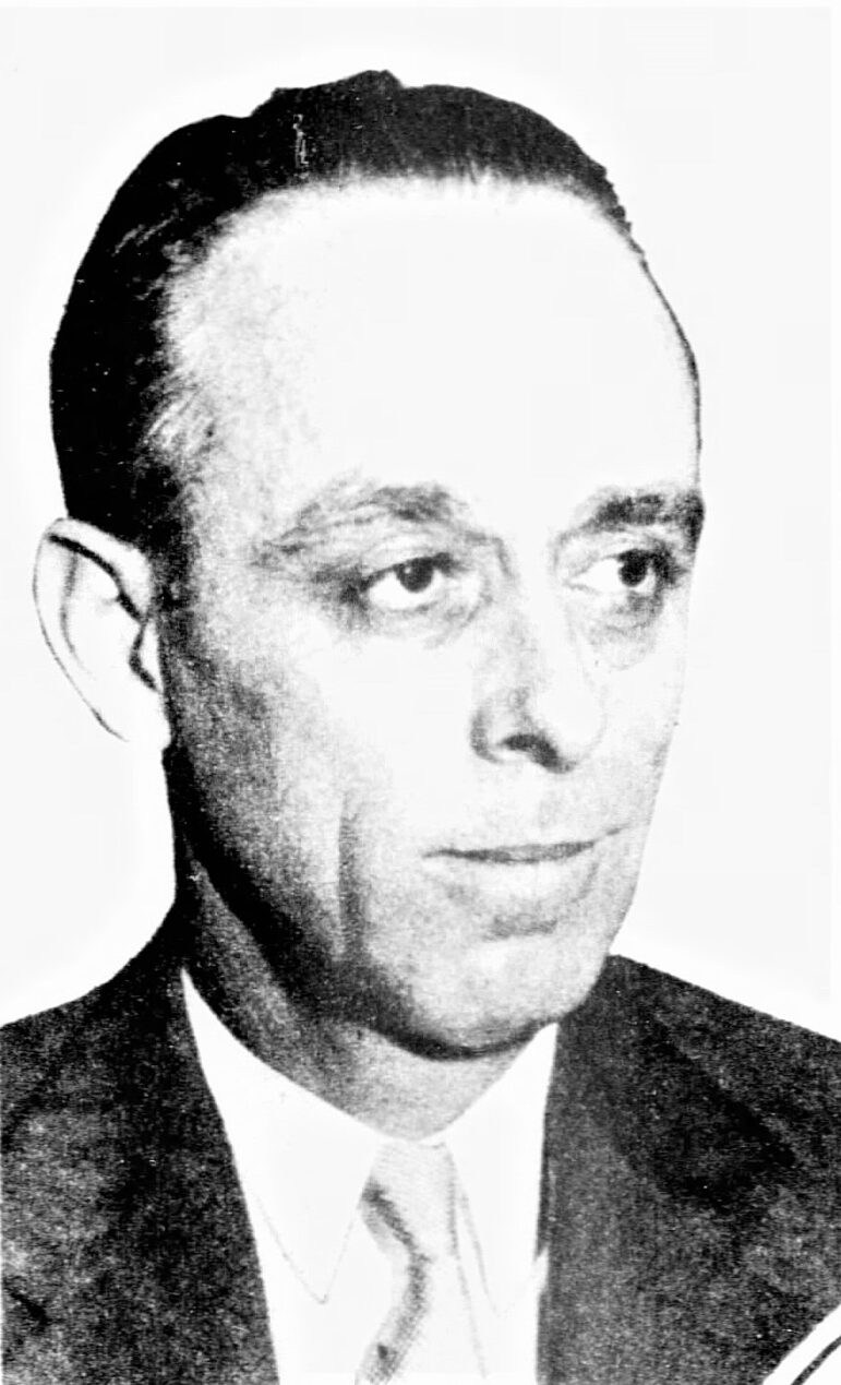 Frank Melville, then living as William H. Collins, in a black-and-white portrait from the 1930s. Melville has a long face and is partially bald. He is wearing a suit.