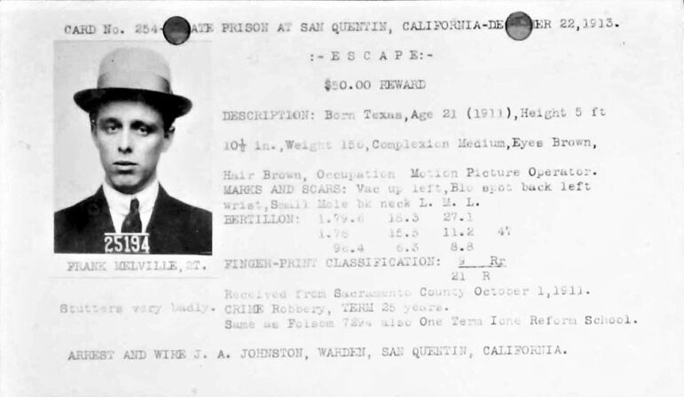 An index card with Frank Melville's picture and a $50 reward for his re-capture. Melville is wearing a suit, tie and hat.