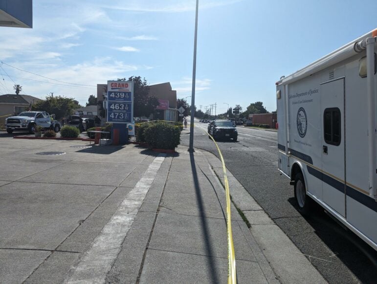 Investigators process evidence of a Vallejo police shooting near a gas station on June 27, 2023 in Vallejo, Calif. It is sunny outside, and a California Department of Justice Bureau of Forensic Services truck can be seen in the foreground.