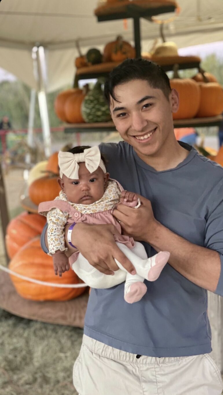 A young man holding his baby