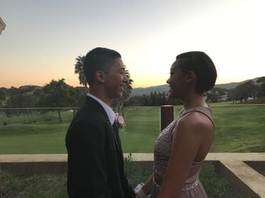 A young couple holding hands outdoors near dusk