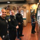Three Vallejo police officers stand at a kitchen counter waiting to take orders to diners during a "tip-a-cop" charity event benefitting the Special Olympics of Northern California.