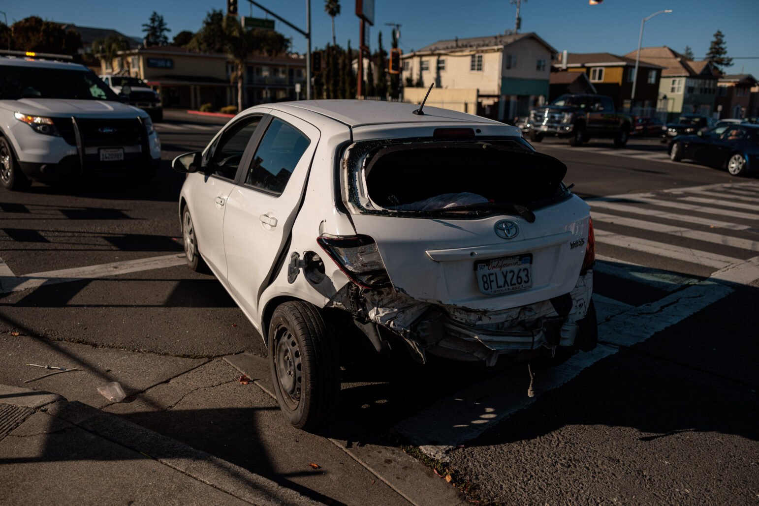 A white Toyota Yaris that has been damaged in a collision.