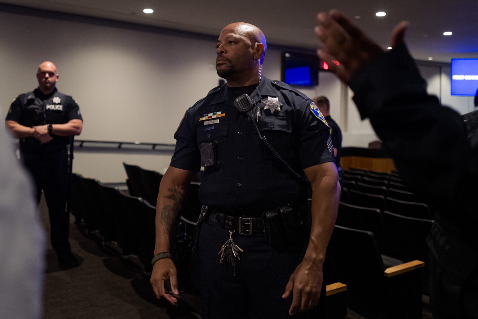 Vallejo Police Ofc. Steve Darden stands in the aisle of the Vallejo City Council chambers, which is nearly empty after police ejected demonstrators and other members of the community.
