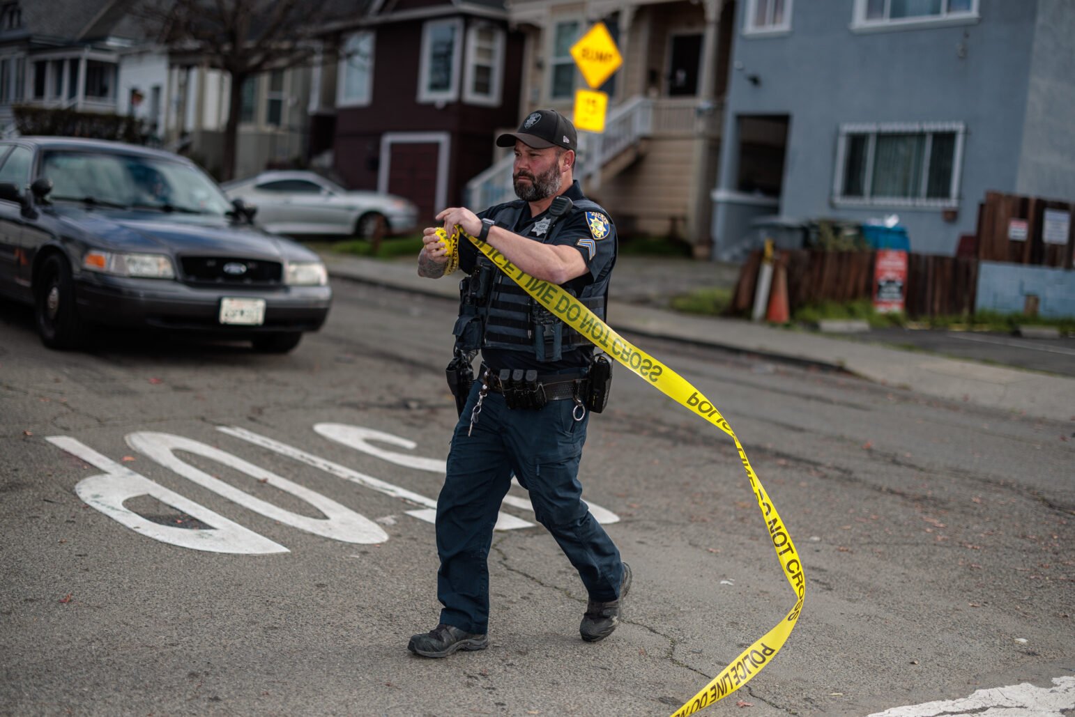 A Vallejo police corporal winds up crime scene tape during daytime.