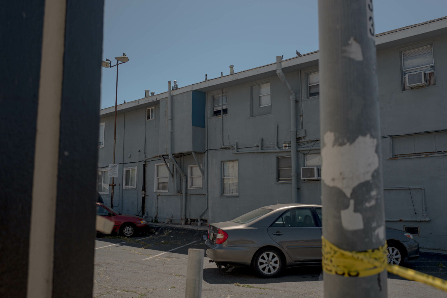 A multi-family home during daytime, as seen across a parking lot.