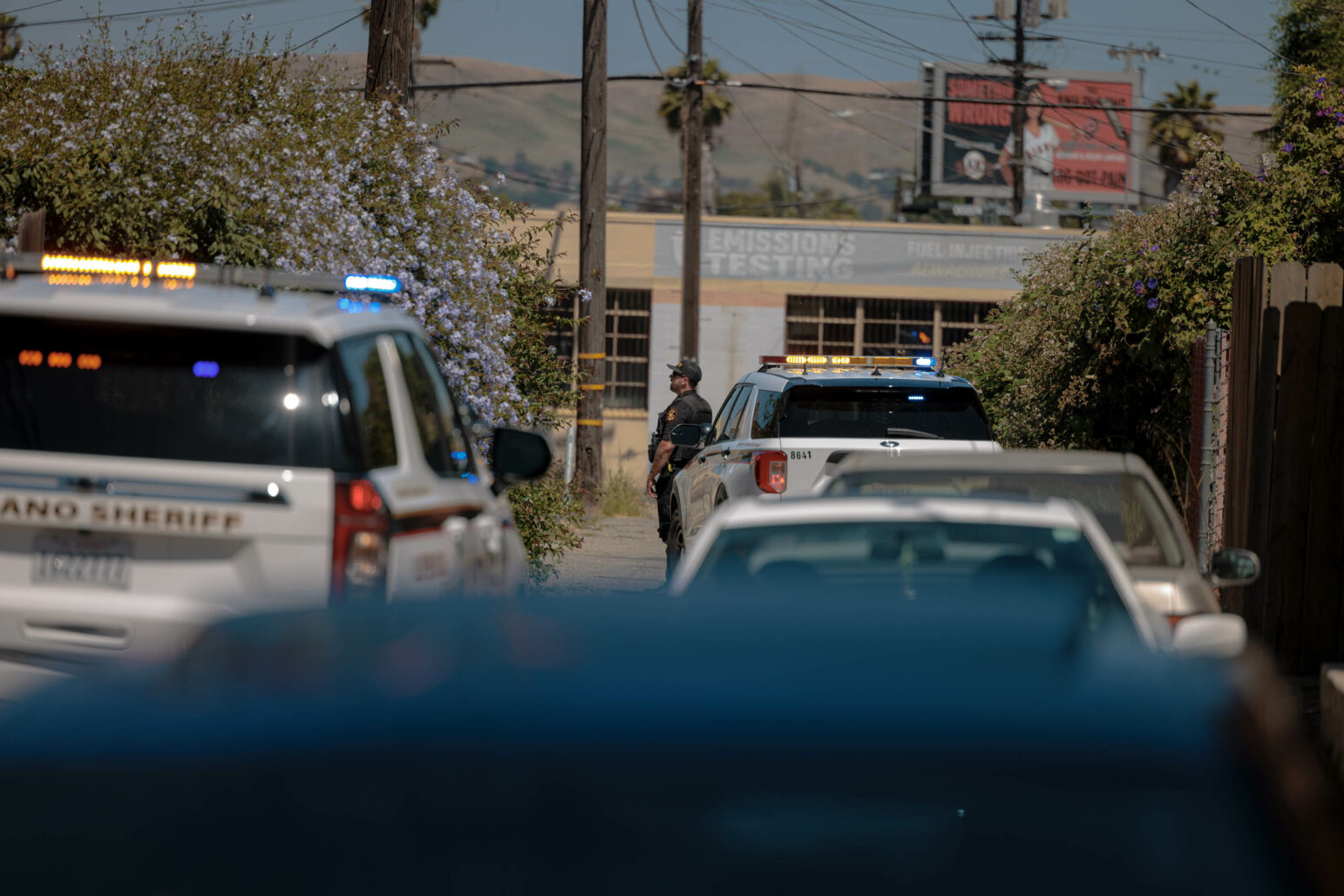 A sheriff's deputy watches a residence during daytime.