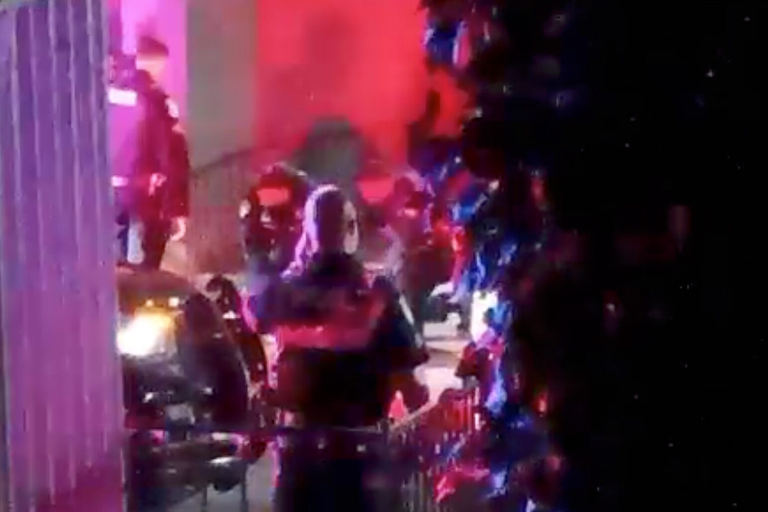 Vallejo police, lit by red and blue lights, attend to a young shooting victim at night.