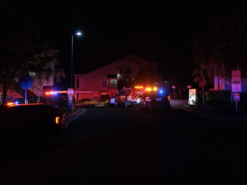 Vallejo police SUVs and a fire truck with their lights on at night.