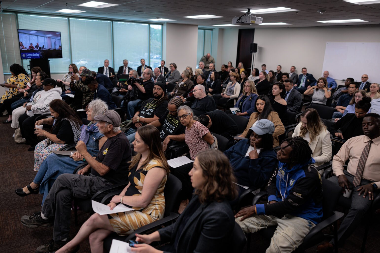 A large room filled with attendees seated, watching a presentation or panel discussion.