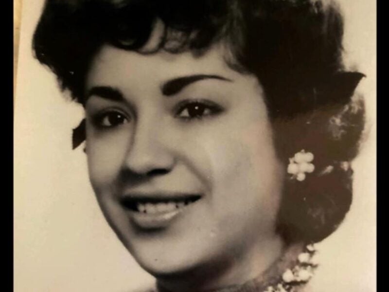 A formal black-and-white studio portrait of a young Evangelina R. Humphrey wearing a dark top and a floral necklace, smiling gently at the camera.